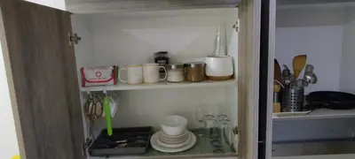 a cupboard with dishes and utensils in a kitchen at Family Suite Staycation FAME Residence 1508 Tower1 in Manila
