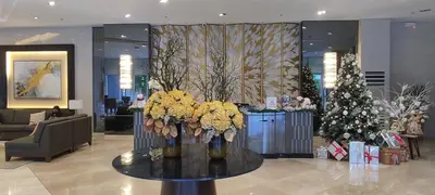 a lobby with a christmas tree and a table with flowers at Family Suite Staycation FAME Residence 1508 Tower1 in Manila
