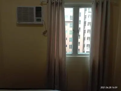 a window with a curtain in a room at The Rochester Condo in Manila