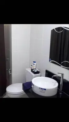 a bathroom with a toilet and a sink at The Rochester Condo in Manila