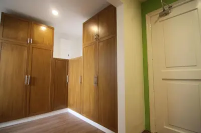 a closet with wooden cabinets and a door at Bryan Condo Suites Makati near Airport in Manila