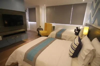 a hotel room with two beds and a flat screen tv at Bryan Condo Suites Makati near Airport in Manila