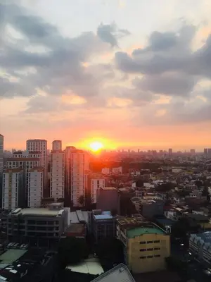 a city skyline with the sun setting in the sky at Ronz Deca Hills in Manila