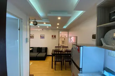 a kitchen and living room with a couch and a table at MidKnight Sky Unit for Rent in Anabu Primero