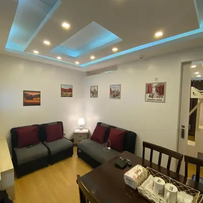 a living room with a couch and a table at MidKnight Sky Unit for Rent in Anabu Primero