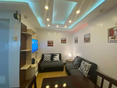 a living room with a couch and a tv at MidKnight Sky Unit for Rent in Anabu Primero