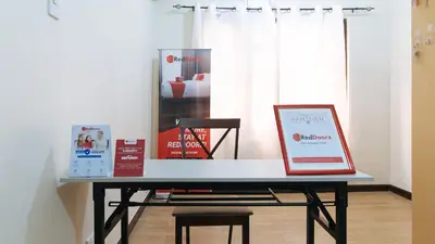 a table with a laptop on it in a room at RedDoorz @ Jolly Orange Paranaque in Manila