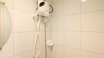 a shower in a bathroom with a phone on the wall at RedDoorz @ Jolly Orange Paranaque in Manila
