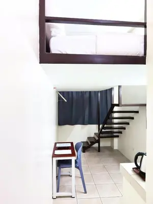 a room with a bed and a table and a chair at airobedz MANILA - A Value Hotel in Manila