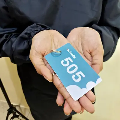 a person holding a tag that says go in their hands at airobedz MANILA - A Value Hotel in Manila
