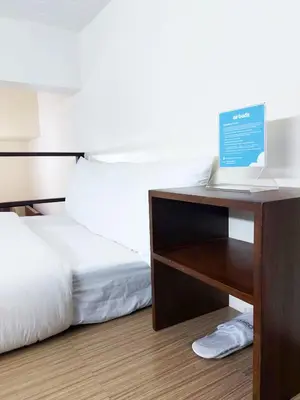 a bedroom with a bed and a laptop on a table at airobedz MANILA - A Value Hotel in Manila