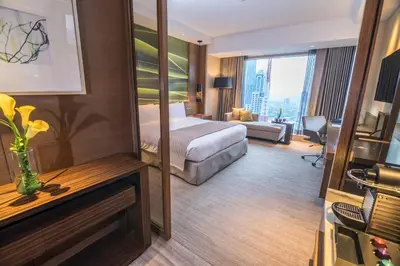 a hotel room with a bed and a large window at Marco Polo Ortigas Manila in Manila