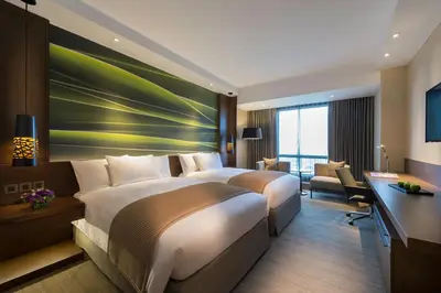 a hotel room with two beds and a desk at Marco Polo Ortigas Manila in Manila