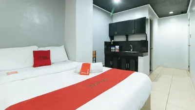 a hotel room with a bed with a red blanket at RedDoorz @ Good 101 Quiricada Manila in Manila