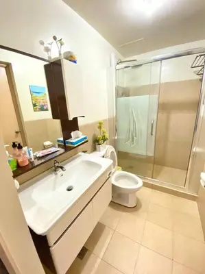 a bathroom with a sink and a toilet and a shower at Field Residences in Manila