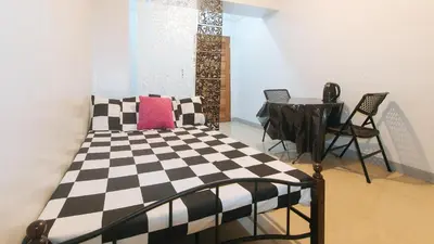 a bedroom with a black and white checkered bed and a table at Budget Backpackers Transient House near NAIA by RedDoorz in Manila