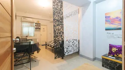 a room with chairs and a table and a wall at Budget Backpackers Transient House near NAIA by RedDoorz in Manila
