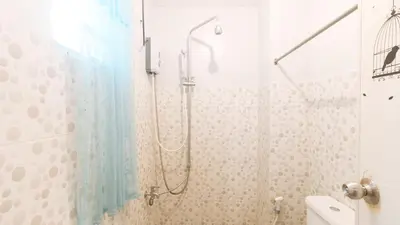 a bathroom with a shower with a glass door at Budget Backpackers Transient House near NAIA by RedDoorz in Manila