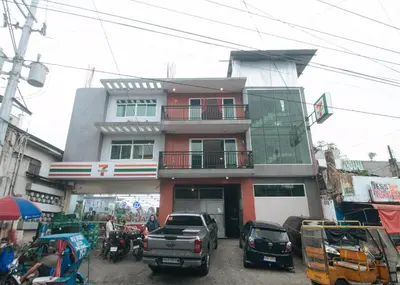 a building with cars parked in front of it at Budget Backpackers Transient House near NAIA by RedDoorz in Manila