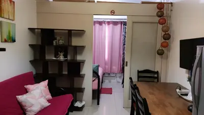 a living room with a red couch and a table at MSH property Sea Residences MOA Pasay City by Queennie in Manila