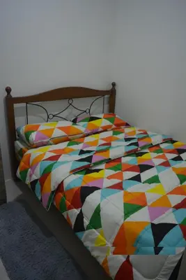 a bed with a colorful comforter on it at Lovely Condo 2-BR w/balcony in SM-Sucat, Paranaque in Manila