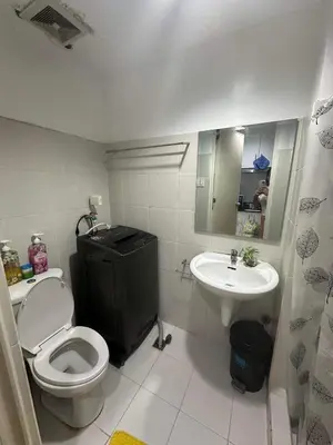 a bathroom with a toilet and a sink at Sea Residences MOA Complex - Ruffa's Condotel in Manila