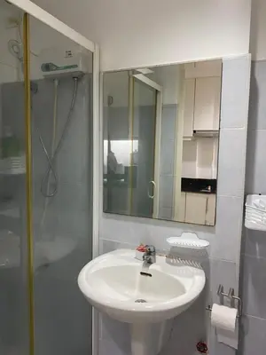 a bathroom with a sink and a shower and a mirror at Sea Residences MOA Complex - Ruffa's Condotel in Manila