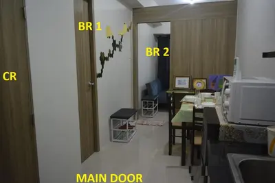 a room with a dining table and a main door at Paranaque SM-Sucat Field Res. Bldg 5, 2/F, 2BR with Balcony in Manila