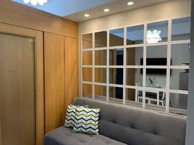 a living room with a gray couch and a window at MOA staycation Shell Residences Pasay city darpm in Manila