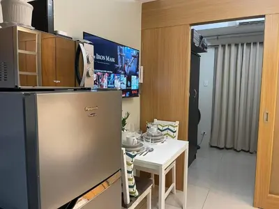 a kitchen with a refrigerator and a white table at MOA staycation Shell Residences Pasay city darpm in Manila