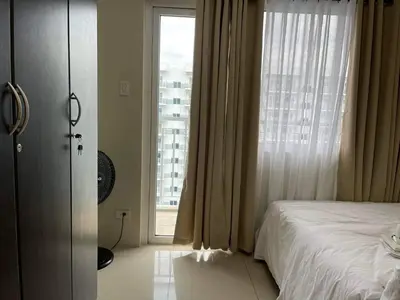 a bedroom with a bed and a large window at MOA staycation Shell Residences Pasay city darpm in Manila