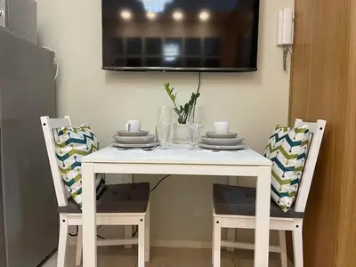 a white table with two chairs and a tv on the wall at MOA staycation Shell Residences Pasay city darpm in Manila