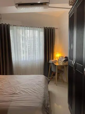 a bedroom with a bed and a desk and a window at MOA staycation Shell Residences Pasay city darpm in Manila
