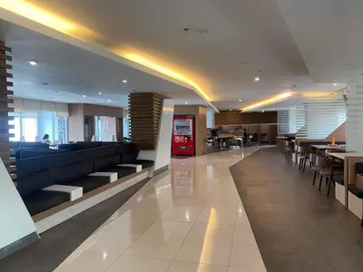 a lobby with a coca cola vending machine and tables at Staycation Taft Ave DLSU Green Res by darpm in Manila