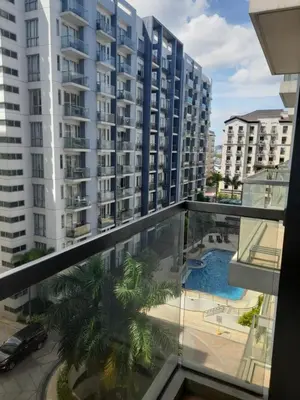 a balcony with a view of a building and a swimming pool at One Palm Tree Villas-Kenzie Place Terminal 3 Airport in Manila