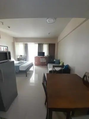 a hotel room with a bed and a table and chairs at One Palm Tree Villas-Kenzie Place Terminal 3 Airport in Manila