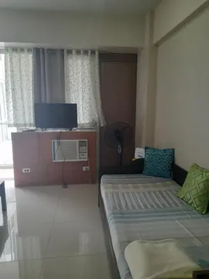a small room with two beds and a tv at One Palm Tree Villas-Kenzie Place Terminal 3 Airport in Manila