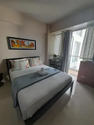 a bedroom with a large bed and a window at One Palm Tree Villas-Kenzie Place Terminal 3 Airport in Manila