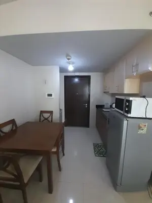 a small kitchen with a table and a refrigerator at One Palm Tree Villas-Kenzie Place Terminal 3 Airport in Manila