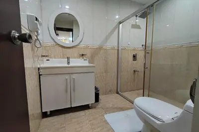 a bathroom with a toilet and a sink and a shower at Manila Crown Palace Hotel in Manila