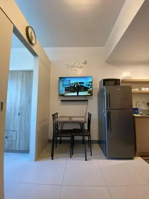 a kitchen with a table and a refrigerator at A Cozy 1 Bedroom Unit with a Parking at Tower 2 South Residences SM Southmall in Manila