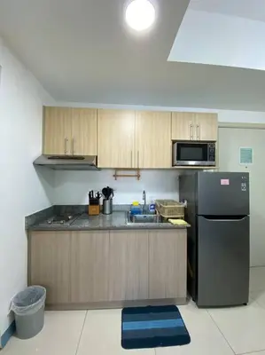 a kitchen with a black refrigerator and a microwave at A Cozy 2 Bedroom Unit with a Parking at Tower 2 South Residences SM Southmall in Manila