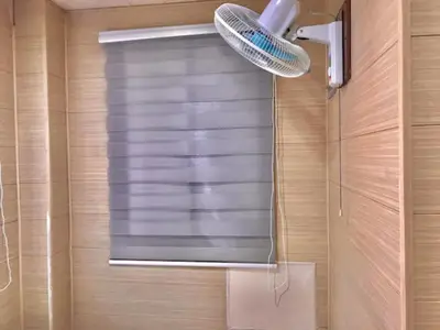 a bathroom with a shower with a window and a light at Maine City Residences Leveriza in Manila