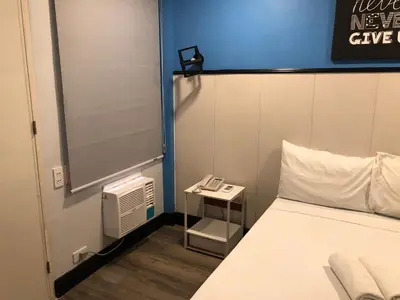 a room with a bed and a phone on a table at Maine City Residences Leveriza in Manila