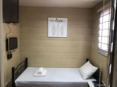 a small room with a bed and a telephone at Maine City Residences Leveriza in Manila
