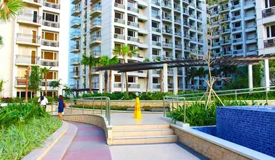 a woman walking down a walkway in front of a building at FRD Condo Unit Tower A SoleMare Parksuites in Manila