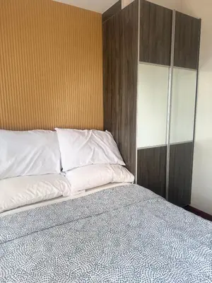 a bedroom with a bed and a wooden headboard at FRD Condo Unit Tower A SoleMare Parksuites in Manila