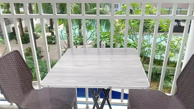 a white table and chairs on a balcony at SHORE RESIDENCE d6, shortwalk Mall of Asia near Airport in Manila