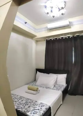 a small bedroom with a bed with a black curtain at Moa's Spot at Sea Residences in Manila