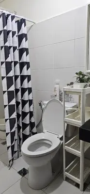 a bathroom with a toilet and a black and white shower curtain at Your Crib - kasara -19 D tower 1 in Manila